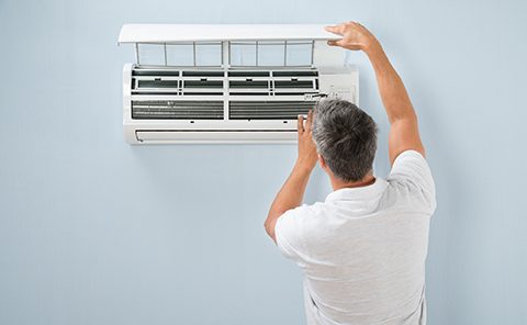 Man checking AC wall system.